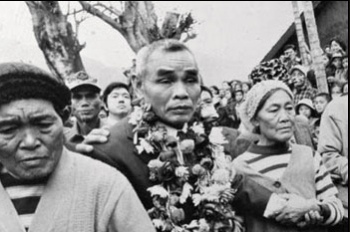 A bewildered-looking Nakamura is garlanded with flowers on his emergence from the jungles of Morotai.