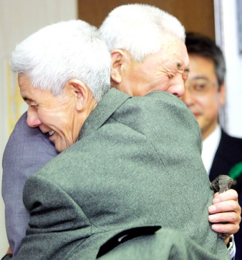 Uwano Ishinosuke (front) hugs his 81-year-old younger brother Sadake Ushitaro as they are reunited for the first time in well over 60 years.